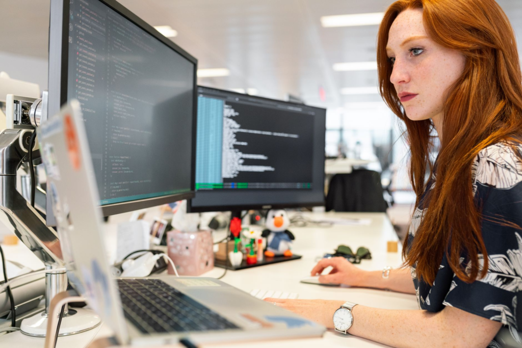 Specialist voert een AI-pentest uit en bekijkt de code op twee schermen